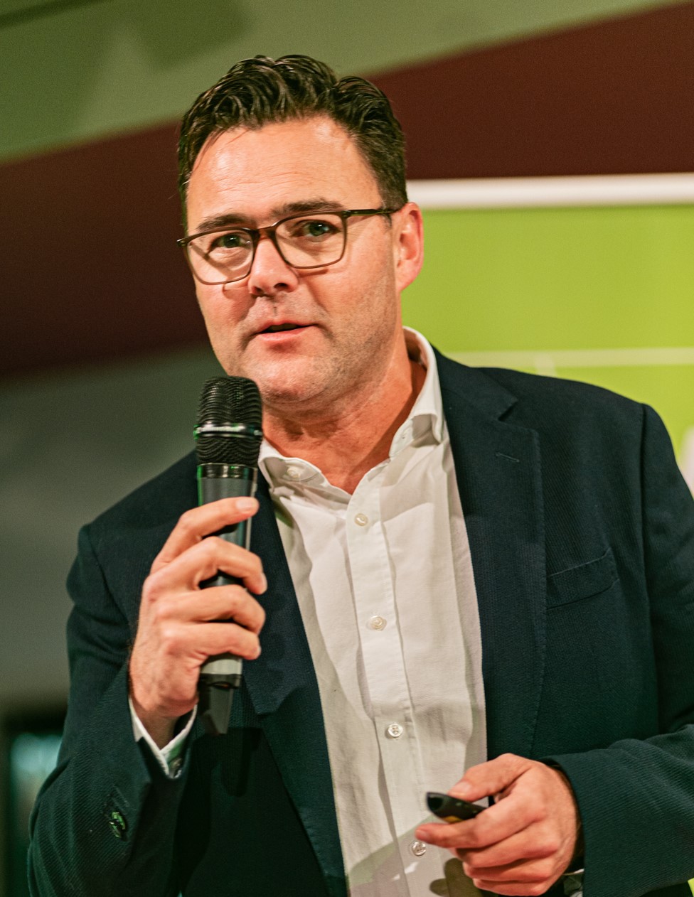 Carl Maes speaking on stage