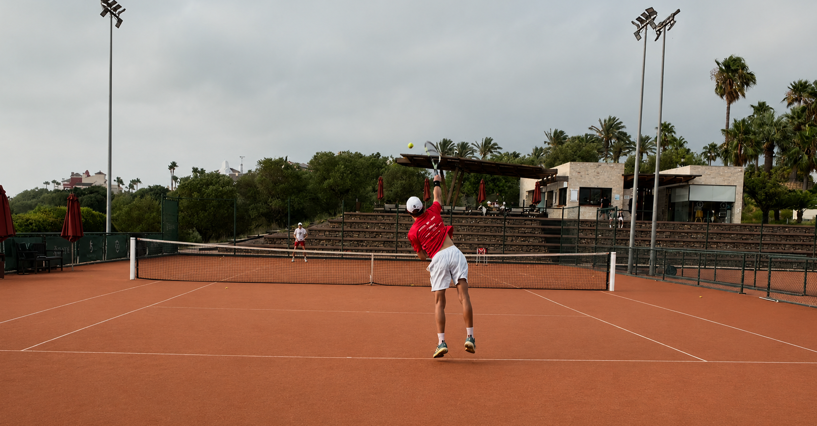 Player serving on a clay court in Sotogrande, South of Spain